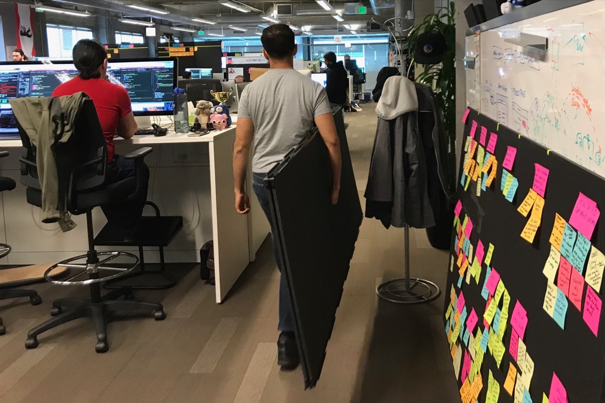 A man carries a pair of SHAY boards around the office